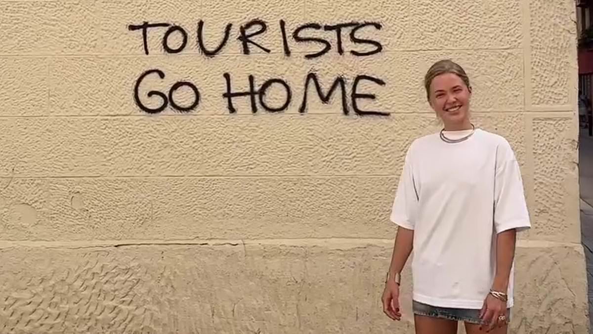 Holidaymaker enrages Barcelona locals as she poses next to ‘tourists go home’ graffiti and thanks residents for their ‘very warm welcome’ amid continued anti-tourism protests [Video]