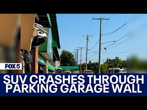 SUV crashes through Whole Foods parking garage wall, hangs partially over edge [Video]